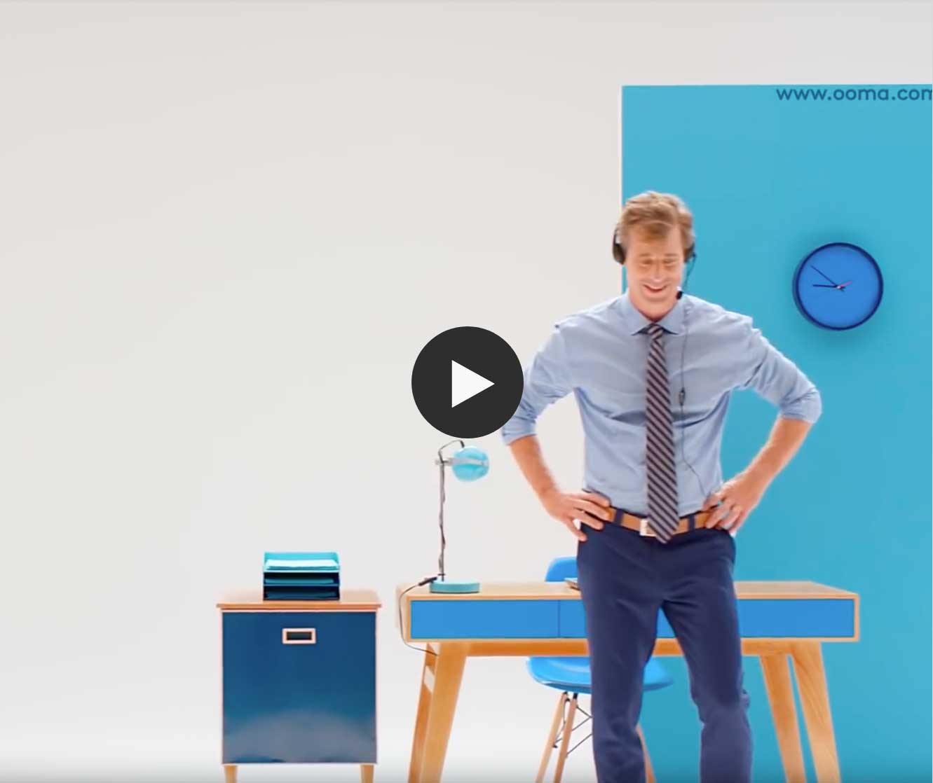 A man standing with a headset in front of a desk - ooma telo device video overview image