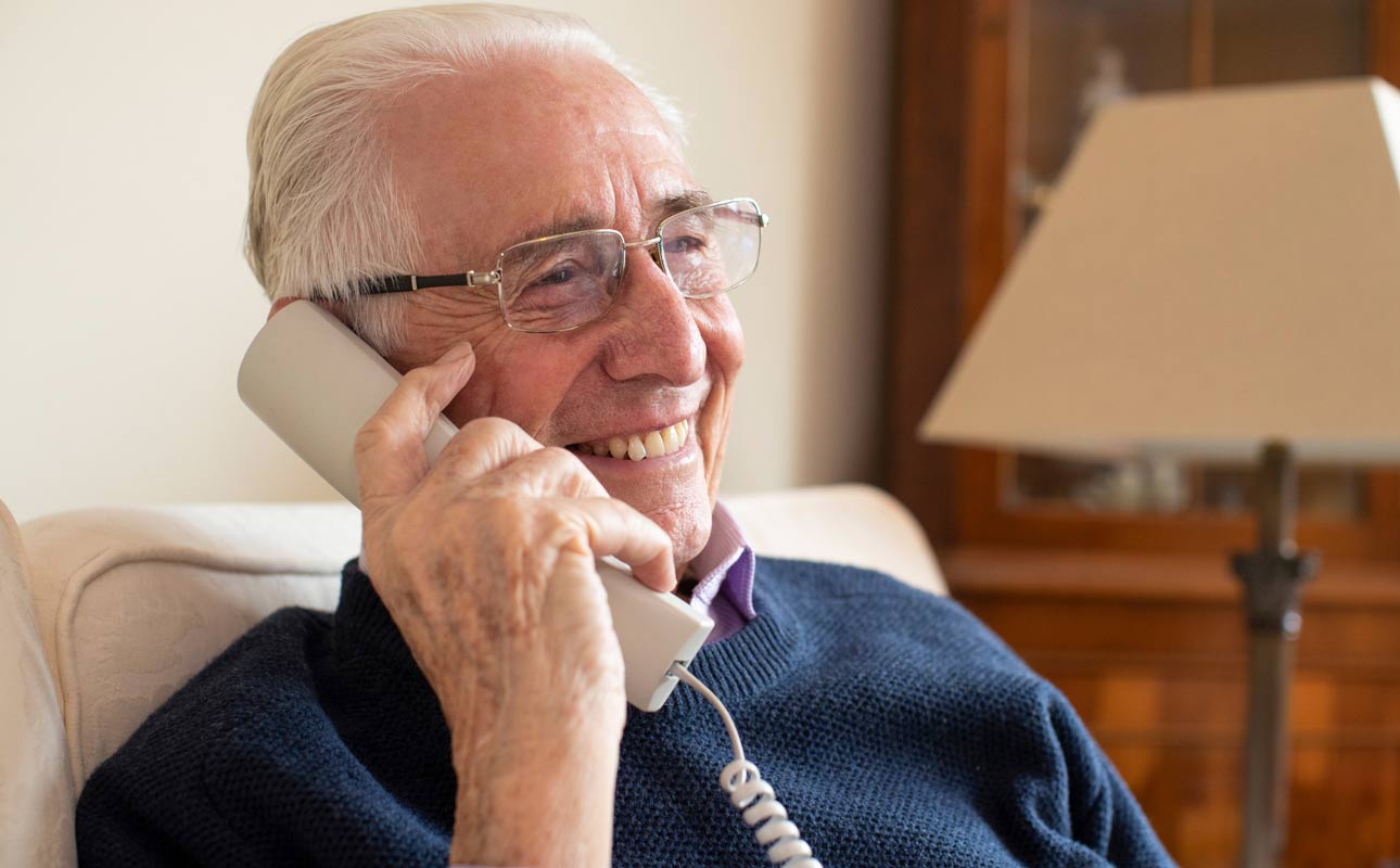 Seated man using a landline phone