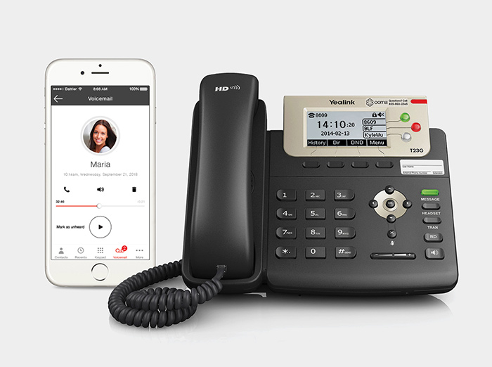 Smartphone alongside an Ooma Yealink business phone