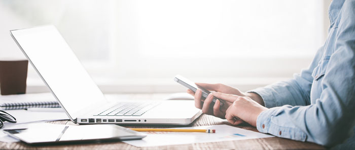 close-up of person using a smartphone at an office desk